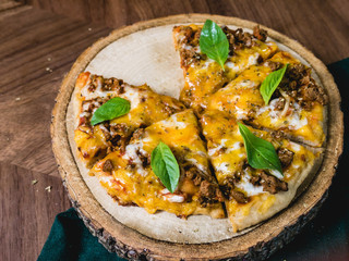 fresh baked crisp pizza with meat cheese and fresh Basil leaf