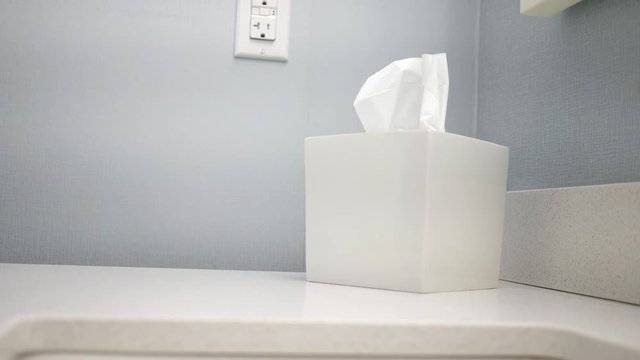 A man grabs a tissue from modern tissue box