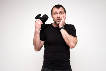 portrait of a pretty photographer on a white background with a camera in his hand