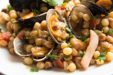 Fregula con frutti di mare, traditional sardinian durum wheat pasta with seafood 