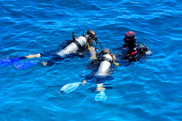 Divers on the clear and turquoise Red Sea on immersion in beautiful corals and colorful fish. The...