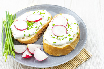 Bread with cheese spread, chives and radishes. healthy breakfast concept. 