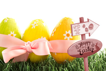 Easter egg hunt sign against three easter eggs wrapped in pink ribbon with a bow