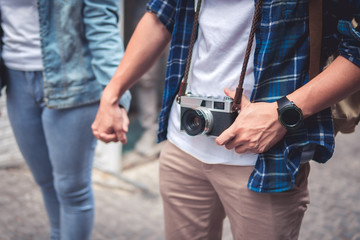 Close up of loving couple holding hands on a street city and hanging camera