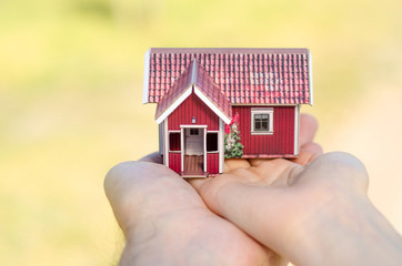 Small house in two hands sun 