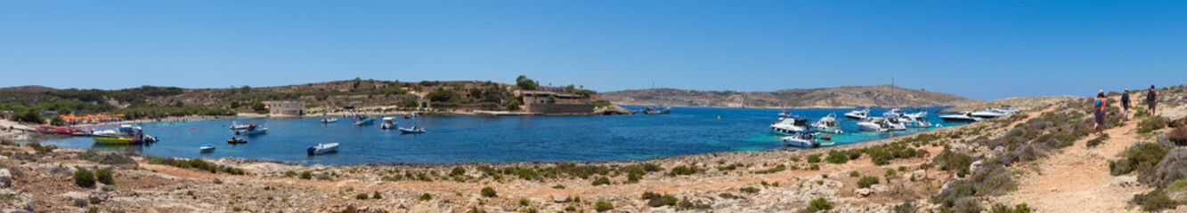 Fototapeta na wymiar High Resolution Panorama of the crystal clear blue waters of Santa Maria Beach in Santa Marija Bay, a large quiet bay on the small holiday island of Comino, Malta, June 2017