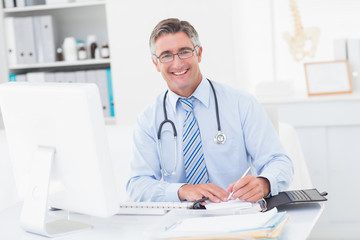 Fototapeta premium Happy smart doctor writing on paper