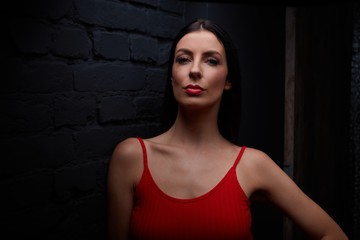 Young woman in red against black wall