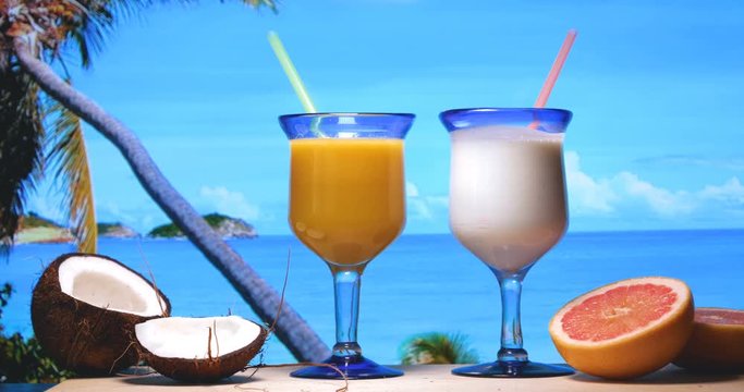 Fresh fruit, grapefruit coconut, frozen milkshake and orange juice, sea background, water and palm. are minted