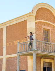 West sheriff guarding the prison with a shotgun on the second floor of the building
