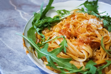 Spaghetti with tomato sauce on the wooden table