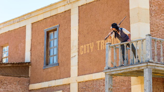 West sheriff guarding the prison with a shotgun on the second floor of the building