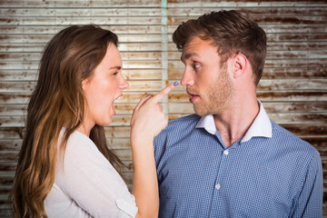 Casual young couple in an argument against wooden planks