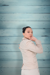 Fototapeta premium Thoughtful asian businesswoman pointing against wooden planks