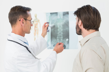 Male doctor explaining spine xray to patient