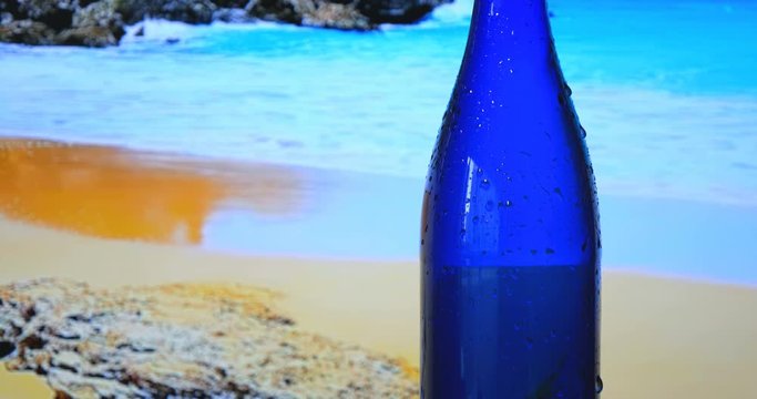Blue bottle with water, background with sea and nature, blue water.