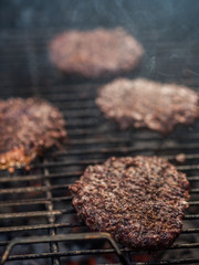 Vertical shot of grilled burgers on hot grill