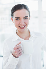 Elegant businesswoman holding coffee cup in office