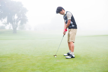 Obraz premium Golfer on the putting green at the hole