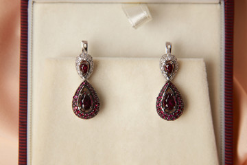 Pair of ruby diamond earrings in jewelry box, close-up. Beautiful luxury brilliant jewelry