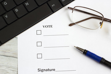 The voting form on the office table near the keyboard, pen and glasses