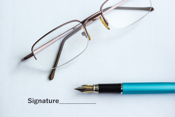 Document for signing beside glasses and pen, close-up