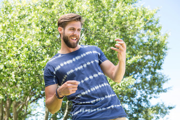 Handsome hipster playing air guitar