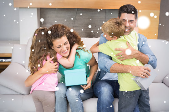 Young siblings giving presents to their parents against snow