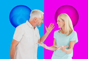 Fototapeta premium Unhappy couple having an argument against pink and blue