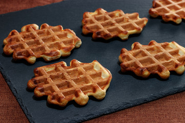 Vienna waffles lie on a stone, black slate board