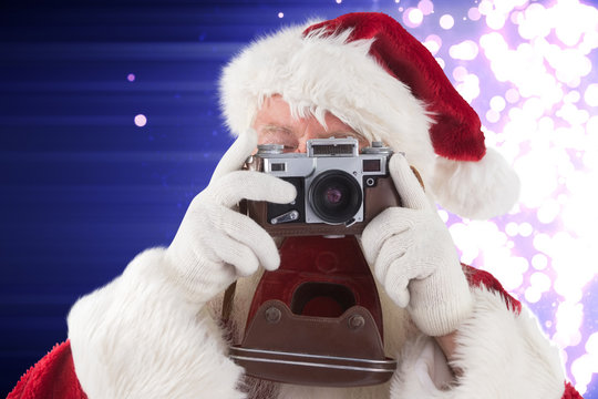 Santa is taking a picture against light design shimmering on purple