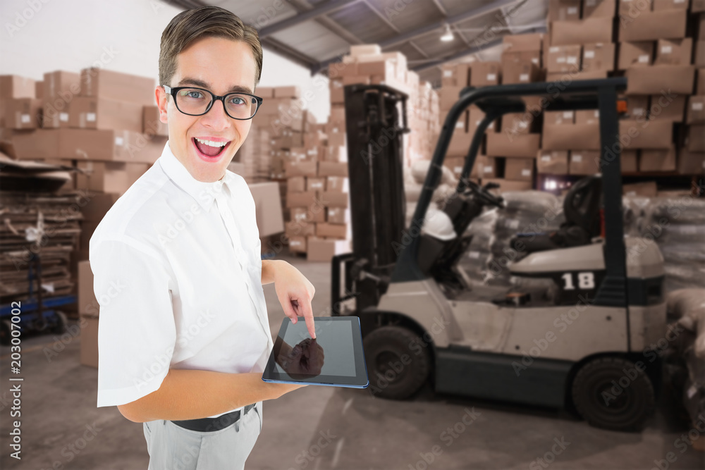 Poster geeky businessman using his tablet pc against warehouse worker loading up pallet