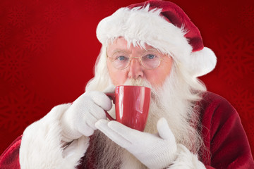 Santa drinks from a red cup against red background