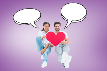 Cute couple sitting holding red heart against purple vignette