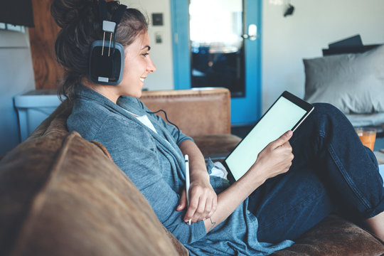 Young Nice Woman Reading Using Tablet Pc, Cozy Studio Apartment