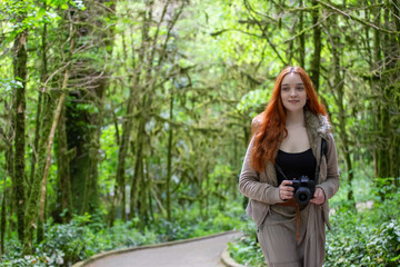 Fototapeta na wymiar girl-photographer in the forest