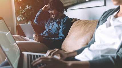 Man and woman working together, using digital devices and laptops