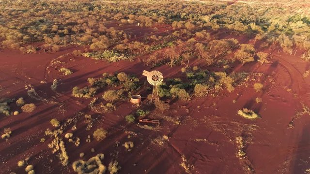 Aerial view of windmill in red desert flying over top in Karijini NP.