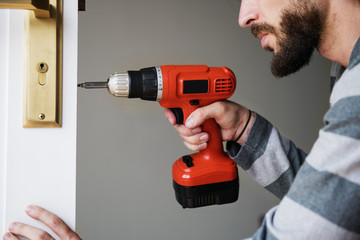 Man using electronic drill install door