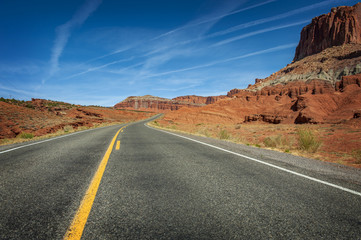 Fototapeta na wymiar Highway to Capitol Reef National Park, Utah. This highway travels through red sandstone rock canyons and scenic desert terrain.