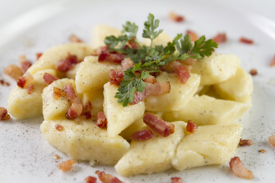 Homemade cottage cheese gnocchi or vareniki or kopytka. Traditional dish in many countries. Polish version with  pork scratching. Made form potatoes,fluor and cottage cheese. Selective focus.