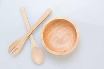Wooden bowl with spoon and practice on white background, top view