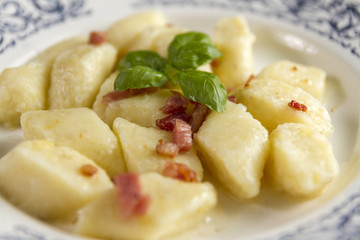 Homemade cottage cheese gnocchi or vareniki or kopytka. Traditional dish in many countries. Polish version with  pork scratching. Made form potatoes,fluor and cottage cheese. Selective focus.