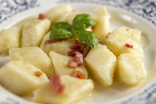 Homemade cottage cheese gnocchi or vareniki or kopytka. Traditional dish in many countries. Polish version with  pork scratching. Made form potatoes,fluor and cottage cheese. Selective focus.
