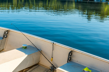 Obraz premium Fishing boat in calm lake water, old motor boat