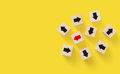 Wooden block with red arrow facing the opposite direction black arrows, Unique, think different, individual and standing out from the crowd concept