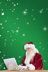 Santa surfs on the internet against green
