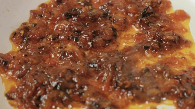 Prepare sause from onion, garlic and tomatoes in frying pan. Closeup view.