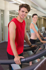 Fototapeta premium Smilng man and woman on the treadmills