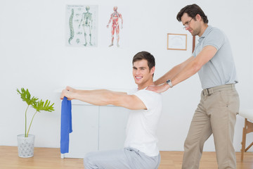Obraz premium Male therapist assisting young man with exercises